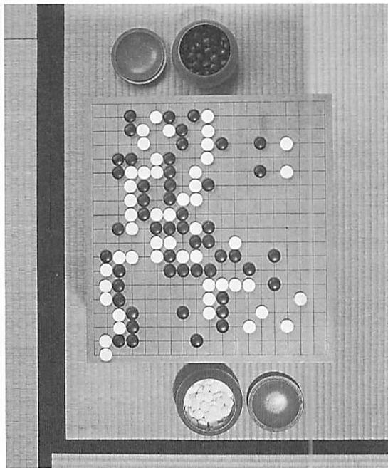 A game of Go, organized by the interlock of black and white stones on the board