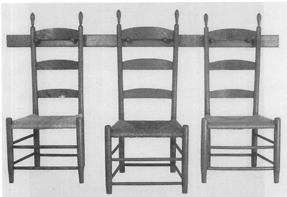 Shaker chairs hanging from pegs around the room and forming a